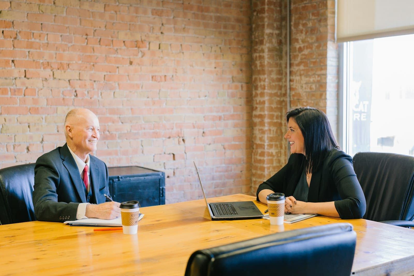 Two colleagues talking through a question across an office table