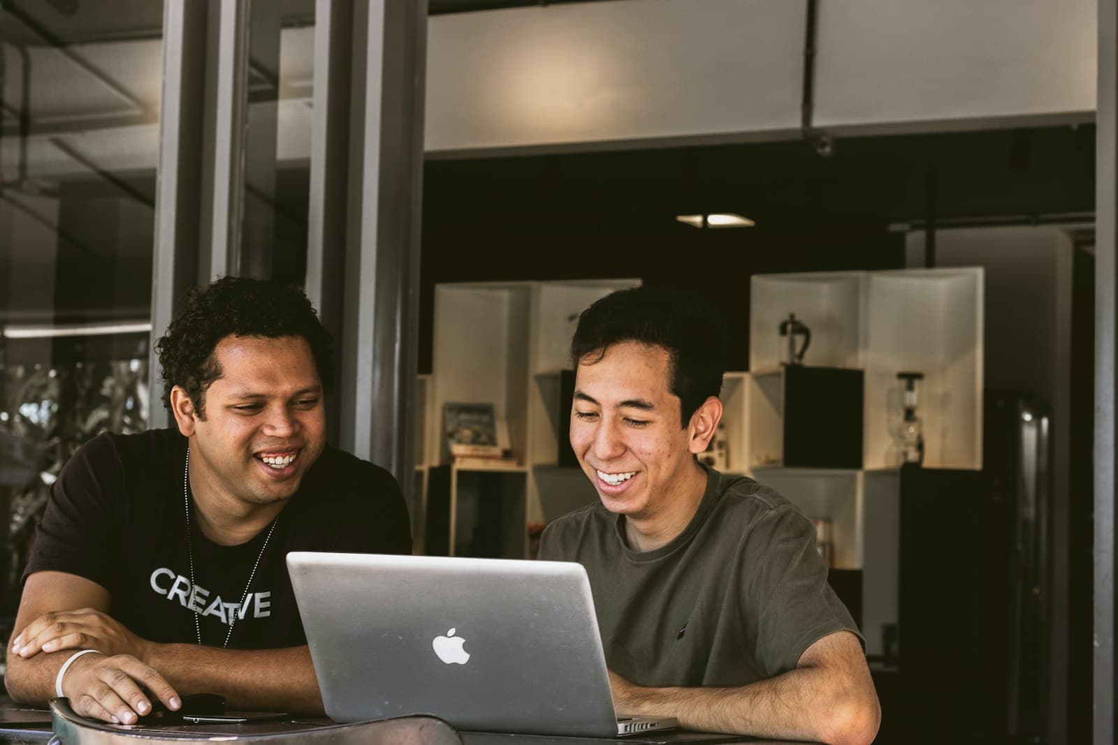Two people working through a system together on one laptop