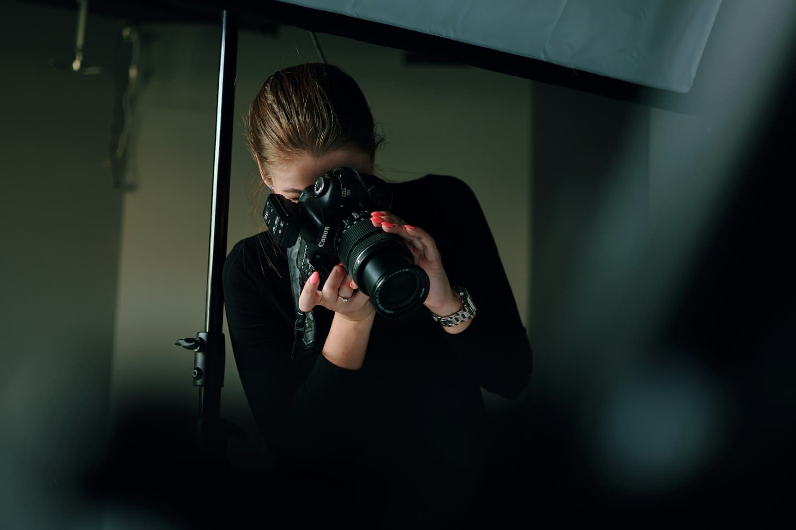 Photographer framing a product shot in a dark studio