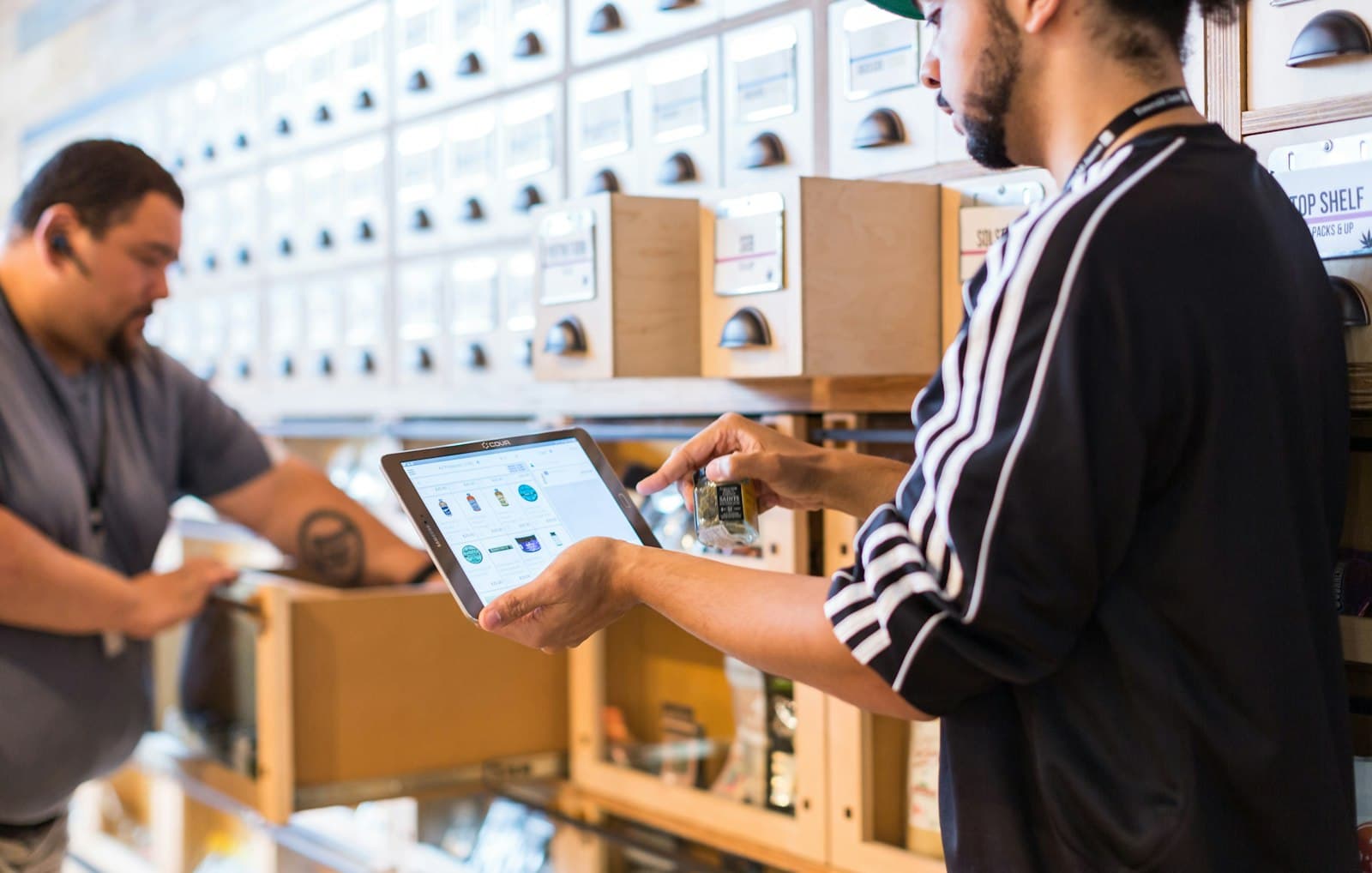 Two sales reps reviewing an order on a tablet in a retail store